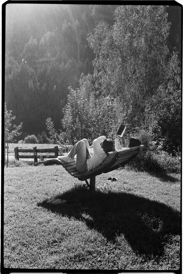 Film photo of a woman relaxing on a wooden lounger