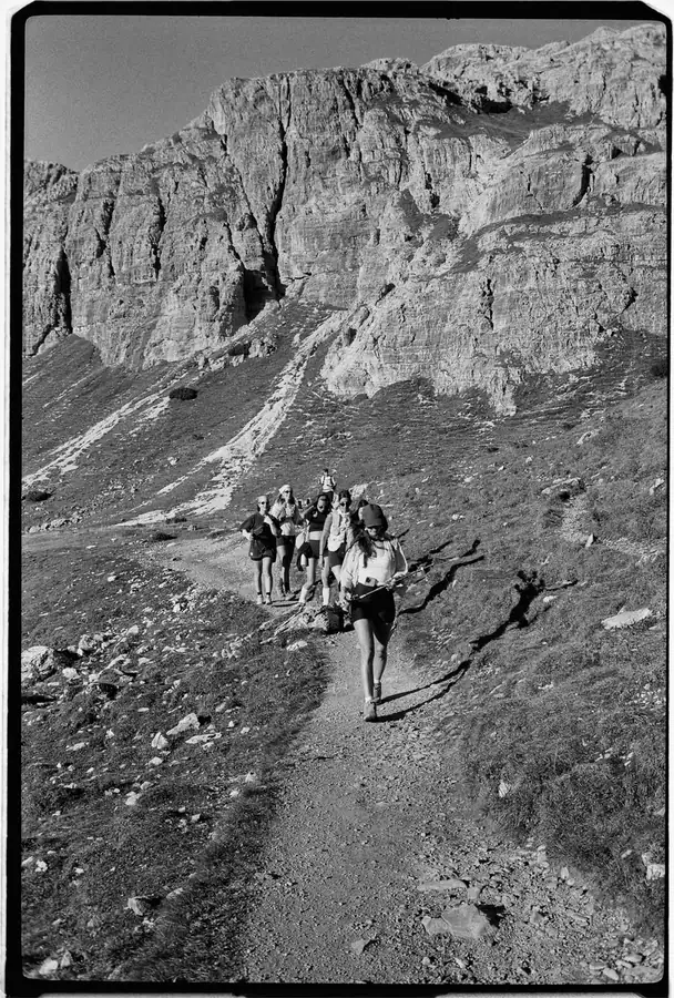 Black and white film photo of hikers on a rocky trail
