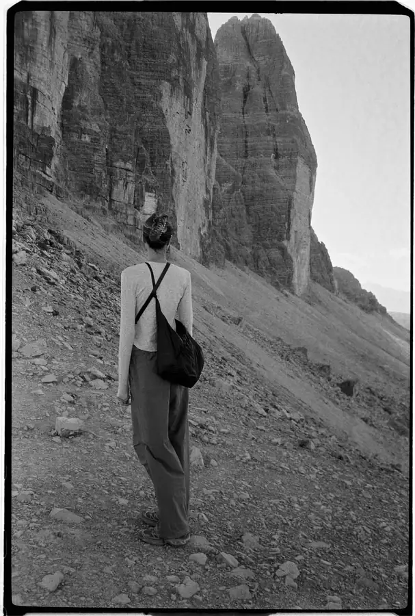 Film photo of a woman walking below the Tre Cime