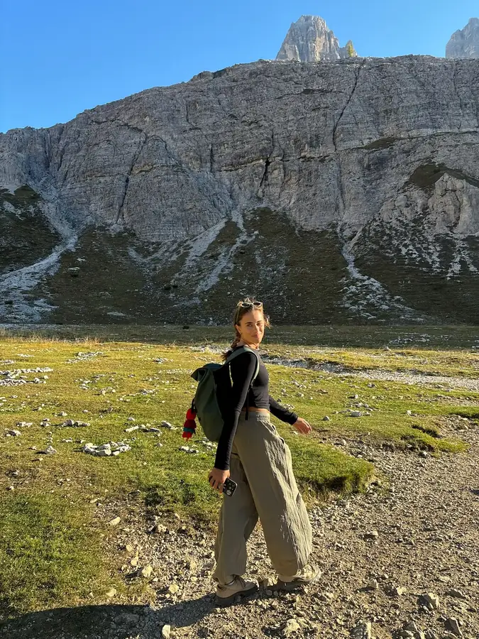 A hiker in wide trousers on an alpine meadow