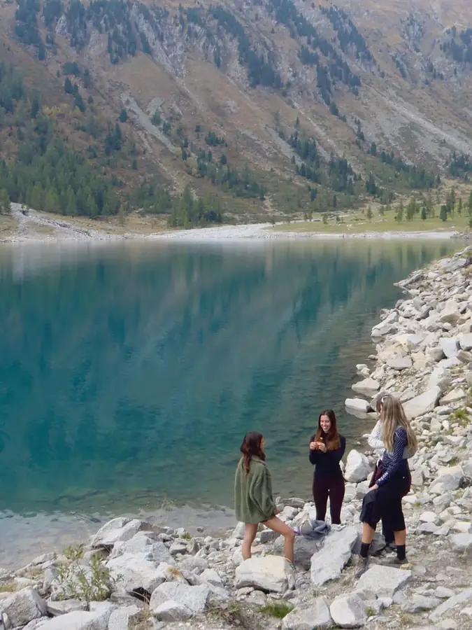 Friends on the rocks of a teal lake