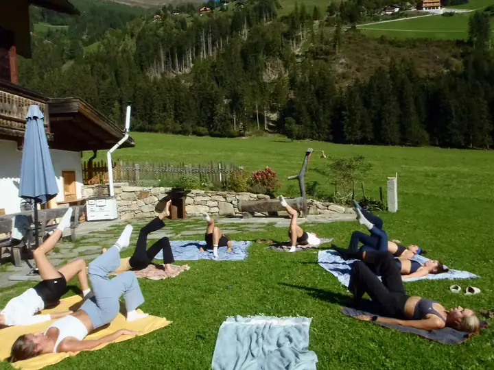 Outdoor pilates session on a lawn by a chalet